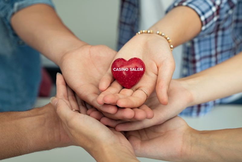 image of many hands holding a heart